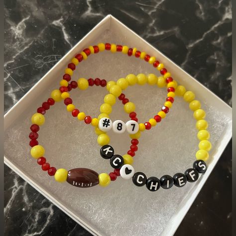 Handmade Kansas City Chiefs Friendship Bracelet Set. Calling All Chiefs Fans And Swifites!!!!! Show Your Support With This Adorable Bracelet Set! Set Comes With 3 Bracelets! One Is A Red And Yellow Beaded Bracelet With A Football Charm, One Is A Red And Yellow Bracelet With #87 For Kelce And Last But Not Least Is The Plain Yellow Beaded Bracelet That Says Kcchiefs. Kansas City Chiefs Friendship Bracelet, Kc Chiefs Beaded Bracelet, Kc Chiefs Bracelet, Chiefs Friendship Bracelet, Chiefs Bracelet Ideas, Chiefs Bracelet, Kansas City Chiefs Jewelry, Swiftie Bracelets, Yellow Beaded Bracelet