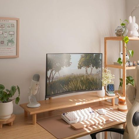 Minimalist desk setup in a bright room, featuring a wide monitor displaying a nature scene, surrounded by small plants and plush toys. The workspace includes a light wooden desk with a white ergonomic chair, and decorative items such as a gaming poster and a small white bunny figurine. Minimal Home Office, Cozy Minimalism, Positive Environment, Dream Desk, Desk Setups, Cozy Home Office, Minimalist Desk, Pc Desk, Minimal Home