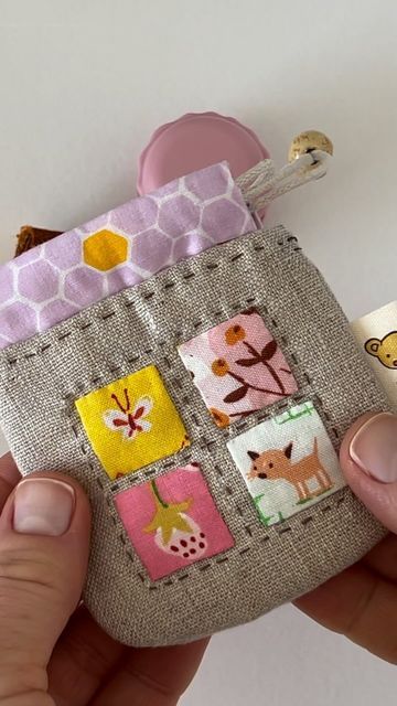 Larisa 🌸 on Instagram: "I really enjoyed sewing this simple mini pouch entirely by hand while I was on holidays. I knew I wanted to take something small with me and quick to make, and something that I could complete by hand. 👏🏻  I used my Mini Drawstring Treasure Pouch pattern, but instead of three small hexies, I added four squares and of course plenty of tiny stitches. 😊  I love using these kind of pouches for small bits and bobs, things like earphones, coins, sewing notions, jewelry, keys… Such a simple and very enjoyable make. ❤️  #stitchingnotes #stitchingnotesvideos #sewing #stitchingnotespattern #handsewn #handmade #handstitched #sewingnotions" Key Fob Coin Pouch Free Pattern, Small Pouch Sewing Pattern, Pouch Sewing Pattern, Button Pouch, Puzzle Bag, Pouch Sewing, Mini Pouch, Pouch Pattern, Mini Pouches