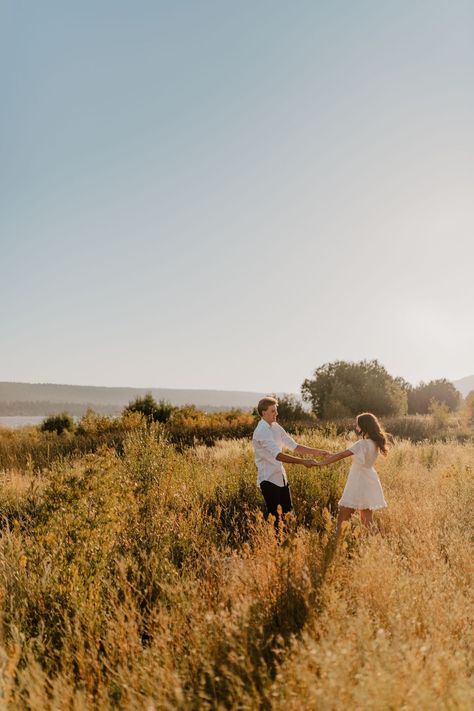 Couple sitting on the ground kissing and cuddling with each  other during their engagement session. Fall Golden Hour Couples Shoot, Fall Sunset Engagement Pictures, Outside Couples Photoshoot, Landscape Engagement Photos, Golden Hour Engagement Shoot, Running Engagement Photos, Engagement Photos Golden Hour, Picture Poses For Couples, Anniversary Picture Ideas