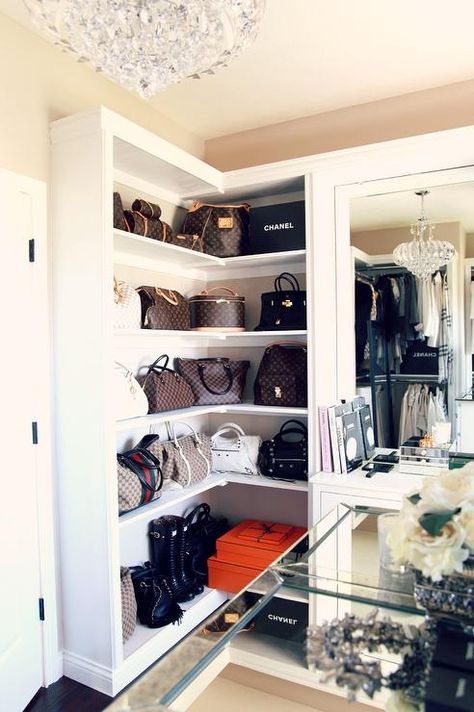 Designer bags sit against a beige wall atop built in white wrap around shelves positioned beside a dresser vanity accented with a mirror illuminated by a crystal chandelier. Toddler Closet Organization, Organization Shoes, Organiser Son Dressing, Toddler Closet, Trendy Closet, Master Closet Organization, Shoe Station, Shoe Organization, Shoes Organizer