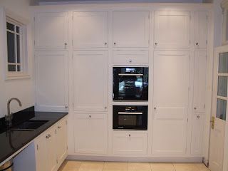 Not many rooms can take huge tall banks of cabinets but they are can be very effective in providing a large amount of storage and hiding of appliances. This bank of units is hiding a small pullout to the right hand side with an integrated fridge next to the oven. An integrated dishwasher is hidden… Painted Shaker Kitchen, Integrated Oven, Paint Shakers, Double Ovens, Tall Kitchen, Above The Sink, Integrated Fridge, Handmade Kitchen, Integrated Dishwasher