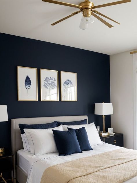 Create a striking focal point in your bedroom with navy blue wall art, complemented by a crisp white bedspread and gold accessories for a touch of elegance. Complete the look with a sleek black nightstand and modern lighting fixtures to add a contemporary feel to your space. Navy Bedroom Walls, Navy Gold Bedroom, Navy Blue Bedroom Walls, White Gold Bedroom, Grey And Gold Bedroom, Blue And Gold Bedroom, White Bedspread, Blue Bedroom Walls, Mens Bedroom Decor