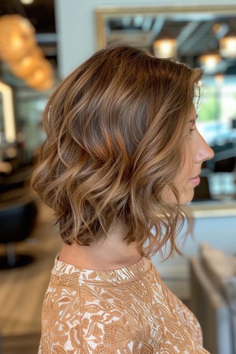 Woman with wavy, short brunette hair styled in a bob, standing in a salon. Light Brown Hair With Cinnamon Highlights, Light Brown Hair With Red Highlights, Light Ginger Brown Hair, Ginger Brown Hair Color, Brown Strands, Ginger Brown Hair, Red Highlights In Brown Hair, Blonde Babylights, Light Ginger