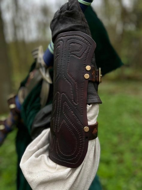 This leather vambrace is a near exact replica to the game, using genuine heavy grade leather for the guard and the straps. The face is decorated by hand. The straps are attached with solid brass rivets in addition to the solid brass buckles. Extra detailing is seen on the side of the straps. The leather is hand dyed and has a beautiful unique colour patterning which makes it look genuine. The vambrace is molded to the forearm and holds its shape, even when unbuckled. Leather Vambrace, Zelda Twilight Princess, The Guard, Twilight Princess, The Legend Of Zelda, Brass Buckle, Mens Costumes, Legend Of Zelda, Rivets