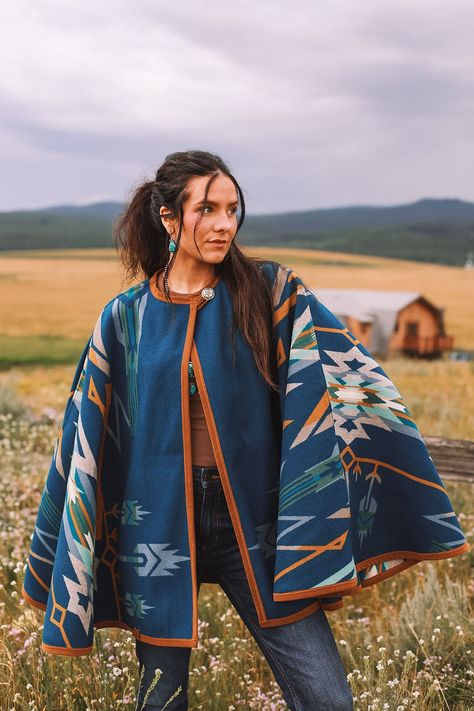 "Bringing back the fun and sensible style of a cape, this will keep you just the right temperature while you're out and about.  Our cape is reversible, offering two wearing options displaying different hues of blue.   Made with the Pendleton® Star Watchers wool blanket. Since ancient times, Native Americans have practiced astronomy to predict the arrival of the brightest stars. Mysterious medicine wheels in Wyoming and Canada track the rising of Aldebaran, Rigel and Sirius, inspiring this dynami Native American Sweater, Native American Scarf, Modern Native American Fashion, Native American Style Outfits, Native American Inspired Fashion, The Evening Star, Native Outfits, American Sweater, Utah Style