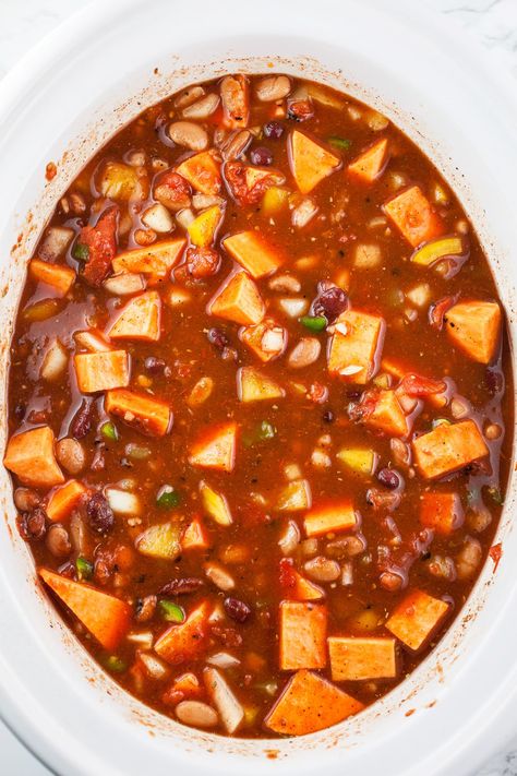 This Slow Cooker Veggie Chili is a hearty and flavorful meal! It's made with garlic, onions, jalapeno, sweet potatoes, kidney and pinto beans, bell peppers, and tomatoes in a crockpot. This chili is flavored with Southwest spices like chili powder, paprika, cumin, and oregano. It's naturally vegan, dairy free, and gluten free. This meatless chili is healthy and perfect for a weeknight dinner! It's perfect topped with a squeeze of lime juice, diced avocadoes, and fresh cilantro. Vegan Recipes Crockpot, Slow Cooker Veggie Chili, Meatless Chili, Slow Cooker Vegetarian Chili, Cold Weather Comfort Food, Vegetarian Chili Recipe, Veggie Chili, Slow Cooker Vegetarian, Gluten Free Vegan Recipes