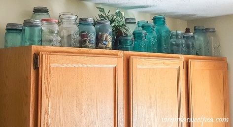 Ideas for Using Mason Jar in Home Decor - Display vintage jars on top of a cabinet. How To Display Old Mason Jars, Antique Mason Jar Ideas, Vintage Jars Display, Blue Ball Jars Decorating With, Mason Jar Display Ideas, Vintage Mason Jar Decor Ideas, Blue Mason Jars Home Decor, Mason Jar Display, Mason Jar Shelf