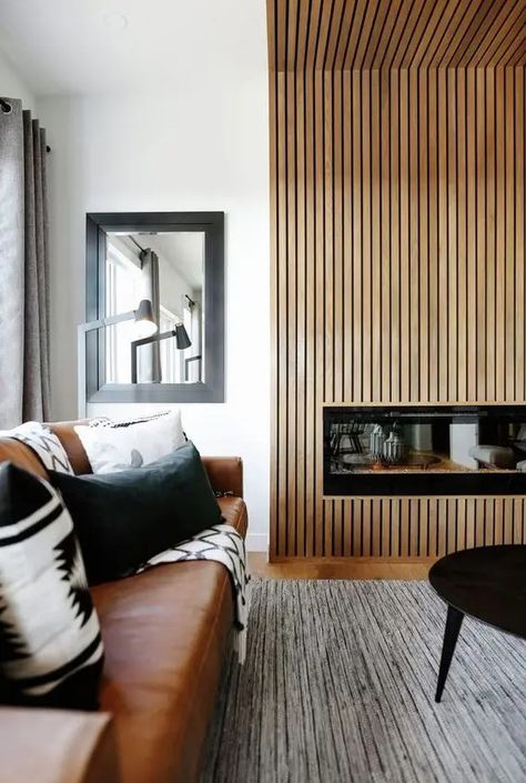 a stylish modern living room with a fireplace clad with a reeded surround, with a leather sofa and black and white pillows, a low coffee table Modular Kitchen Cabinet, Scandinavian Fireplace, Minimalist Fireplace, Black And White Pillows, Nordic Living Room, Fireplace Remodel, Wood Fireplace, White Living, Home Fireplace