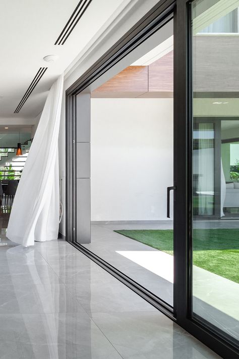 The central idea of ​​the design of this modern private house is based on the integration of the inside and outside. The large sliding doors cover the entire corner of the living room, creating freedom of space and unity with the outdoors. #aluminiumwindows #aluminiumdoors #modernkitchen #modernlivingroom #modernarchitecture Big Glass Doors Living Rooms, Big Glass Sliding Doors, Big Sliding Windows, Big Window Covering Ideas, Large Sliding Door, Big Sliding Glass Doors, Big Sliding Doors, Big Glass Windows Living Rooms, Sliding Glass Door Design