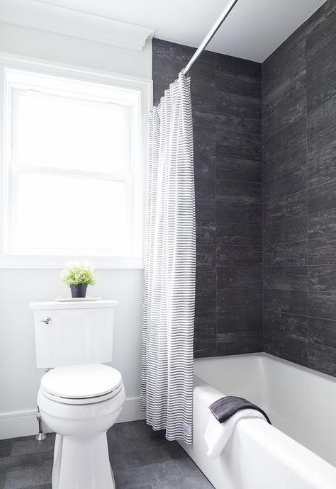 Rustic black and wood like shower wall tiles featured in a drop in bathtub fitted by a black and white striped shower curtain. Black Tile Around Bathtub, Black And White Tub Shower Combo, Black And White Bathtub, Shower Combo Ideas, Shower Wall Tiles, Bathtub Tile Surround, Tile Around Bathtub, Black Tile Bathrooms, Black Bathtub