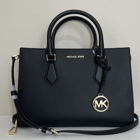 Shop amstar13's closet or find the perfect look from millions of stylists. Fast shipping and buyer protection. New with tags 100% Authentic Michael Kors Sheila Medium Saffiano Leather Satchel Black with Gold tone hardware Style# 35S3G6HS2L Elegantly streamlined, the Sheila satchel is a classic style you can carry all day and into the night. It’s crafted from faux Saffiano Leather with minimal hardware and has internal pockets for organizing your belongings. Carry it by the elegant top ha Black Purse Designer, Michael Kors Handbags Black, Closet Basics, Trendy Purses, Michael Kors Satchel, Black Satchel, Leather Duffle Bag, Leather Duffle, Luxury Purses