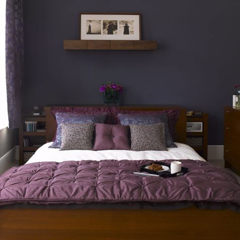 Create a grown-up bedroom scheme with a co-ordinating colour palette in midnight blue, deep plum and charcoal. Paint the main wall in a flat, matt shade to showcase the bed and soft furnishings with furniture kept neat and unfussy in a sleek dark wood veneer. Gothic Dungeon, Midnight Blue Bedroom, Purple Bedroom Design, Tan Shades, Bedroom Eclectic, Small Bedroom Inspiration, Night Tables, Purple Bedrooms, Purple Bedroom