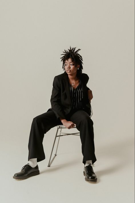 Black woman on locs wearing a suit, sitting on a chair in a studio photoshoot picture. Sitting Fashion Poses, Studio Stool Photoshoot, Grad Photo Outfit Ideas, Wooden Stool Photoshoot, Street Style Studio Photoshoot, Chair Modeling Poses, Photoshoot With Locs, Women In Suits Photoshoot, Poses In Chair