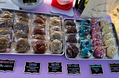 Cookies displayed at a farmers market on silver sheet pans in rows with chalkboard labels Farmers Market Cookies Display, Baked Goods Market Stall, Baking Vendor Booth Ideas, Easy Food Vendor Ideas, Cookies Farmers Market, Baked Goods Vendor Booth, Cookies For Farmers Market, Snacks To Sell At Farmers Market, Bakery Farmers Market Display Baked Goods