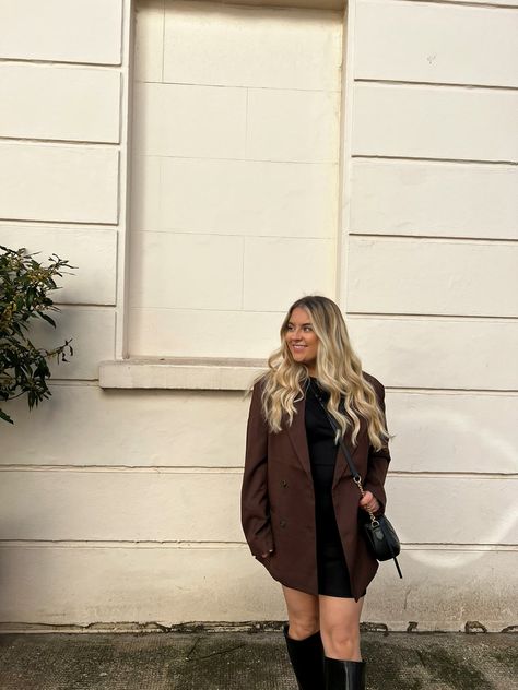 Blonde haired girl wearing a Brown blazer and black dress with black knee high boots looking to her right smiling Blazer With Black Dress, Oversized Blazer With Dress, Black Dress And Black Boots, Blazer And Black Dress, Dress And Black Boots, Brown Blazer Outfit, Oversized Blazer Outfit, Blazer With Dress, Black Boots Outfit