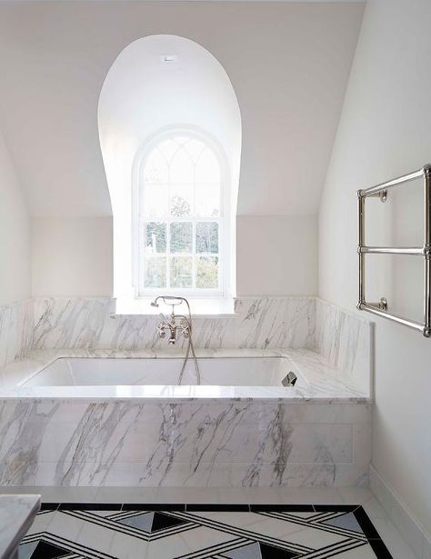 An arched window is located over a marble clad drop-in bathtub matched with a polished nickel tub filler mounted against marble wall tiles. Drop In Tub Ideas, Andrew Howard, Charming Dining Room, Built In Bathtub, Marble Bathtub, Marble Tub, Built In Bath, Drop In Tub, New House Bathroom