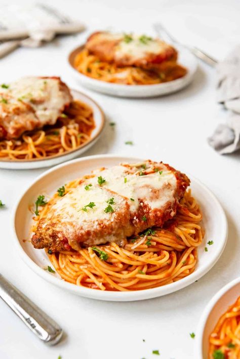 This Chicken Parmesan recipe is made with perfectly seasoned crispy chicken topped with a simple homemade tomato sauce and sliced mozzarella cheese. Pan-seared to develop the crust, then finished in the oven, we love to serve our chicken parm with spaghetti cooked just until al dente and tossed in more of the homemade sauce. | chicken parmesan recipe easy | chicken parmesan pasta | homemade chicken parmesan recipe | homemade chicken parmesan sauce recipe | chicken parmesan with spaghetti recipe Spaghetti And Chicken Parmesan, Chicken Parmesan With Pasta, Chicken Parmesan With Spaghetti, Chicken Parm Recipes, Chicken Parmesan Recipe, Parmesan Recipe, Chicken Parmesan Pasta, Easy Chicken Parmesan, Chicken Parmigiana