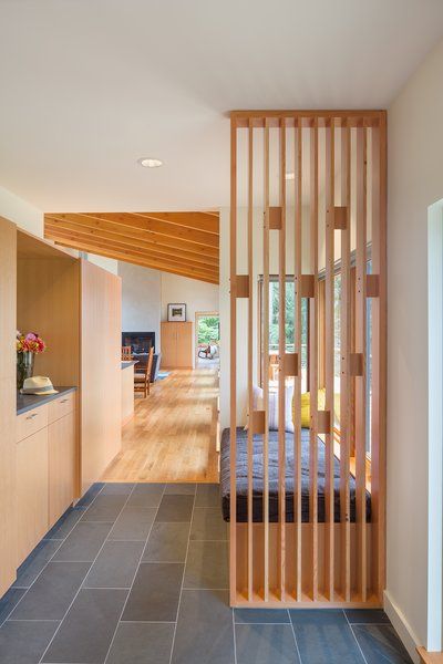 A playful wood screen greets visitors at the front entry, as well as providing support for a cushioned bench seat. Durable materials such as the Doug Fir cabinetry, White Oak flooring and a slate tile floor provide warmth and longevity. Modern Ranch Style Homes, Slate Tile Floor, Slate Wall, Timber Screens, Modern Entry, Wood Screens, Modern Ranch, White Oak Floors, Living Room Partition Design