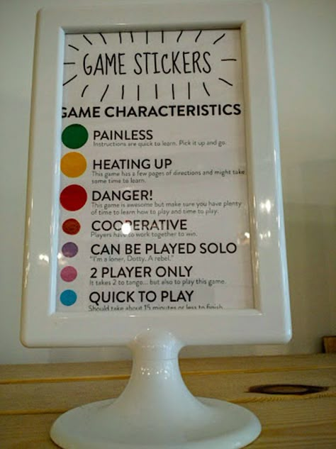 Not sure where to start? Every game has stickers that give you an idea of how long it will take to figure out the rules, how many people are required to play, and how long the game will take. Board Game Bar, Gaming Cafe, Game Lounge, Board Game Store, Board Game Room, Games Room Inspiration, Board Game Cafe, Board Game Storage, Game Cafe