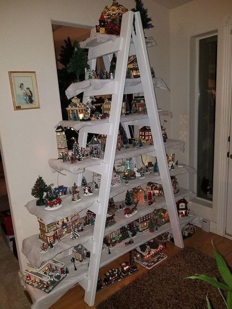 I have no room to display our village at Christmas so I made a ladder for it and then put plants on it during the rest of the year. Both inside or outside of the house.  I hope you enjoy it.  I purchased four 2 X 4s eight feet long.  And six 1 X 4. Two gate hindg's and deck screws.  White enamel paint.  I Laid the four  2 X 4's end to end and screwed a gate hinge to each end.  This way the main post will be foldable.    I measured a… Ladder Christmas Tree Village, Christmas Village Display Shelves, Christmas Village Ladder Display, Shelf For Christmas Village, Christmas Decor Ideas For Chandelier, Ways To Display Christmas Village, Xmas Display, House Ladder, Christmas Ladder