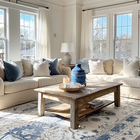 Stylish living room with beige sofas, wooden coffee table, and blue and white area rug, bathed in natural sunlight. A serene and chic space for relaxation. Blue And White Area Rug, Beige Sofas, Serene Living Room, Blue And White Living Room, Chic Living Room Decor, Beige Living Rooms, Beige Sofa, Chic Living Room, Blue Sofa