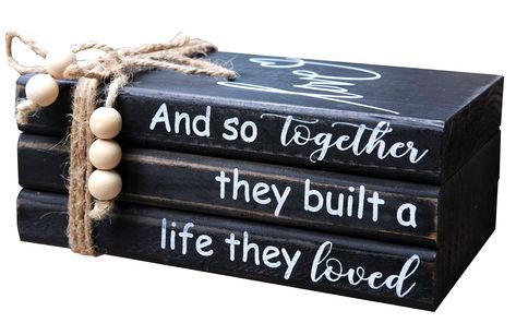 PRICES MAY VARY. 【HANDCRAFTED WOOD BOOK STACK】This farmhouse stacked books decor consists of 3 books made of solid cedarwood. Black painted with slight distressing finish. Cute "Love" printed on top book face, while books' spine has warm inspirational quote "And so together they built a life they loved". 3 farmhouse wood books glued together, won't move to get loose, bookstack bound with rustic twine,the hemp rope's ends are threaded with wood beads. 【IDEAL FOR HOME DECOR】This farmhouse inspired Stacked Books Decor, Diy Wood Books, Table Books Decor, Books Coffee Table, Coffee Table Books Decor, Stacked Books, Books Decor, Black Farmhouse, Books Coffee