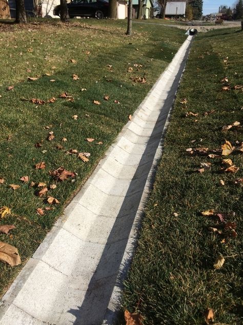 The ditch block is installed at a slight pitch to promote drainage towards a designated direction. Project installed by Dresen Landscape Contractors in Racine, WI. Ditch Ideas, Yard Drain, Gutter Drainage, Landscape Drainage, Backyard Drainage, Drainage Ditch, Yard Drainage, French Drain, Drainage Solutions