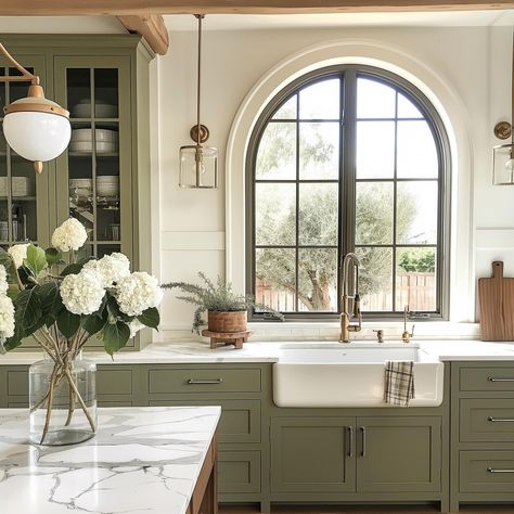 Olive green is one of the trending colors of the year! These cabinets play on trend while remaining a timeless contrast, and I love the warmth they add to this space. With a modern color, these rustic beams, farmhouse sink, and English cottage finishes help create a beautiful balance! AI Design: @oakhavendesignco . . . . . . . . . . #virtualdesign #virtualdesignservices #edesign #virtualhomedesign #moodboards #luxeathome #visionboards #prettylittleinteriors #interiorstyle #smmakelifebeauti... Arch Window Kitchen Sink, Arch Over Kitchen Sink, Arched Window Kitchen, Arched Kitchen Window, Arch Over Stove, Olive Green Interior Design, Modern English Cottage Interiors, English Kitchen Design, Green Farmhouse Kitchen