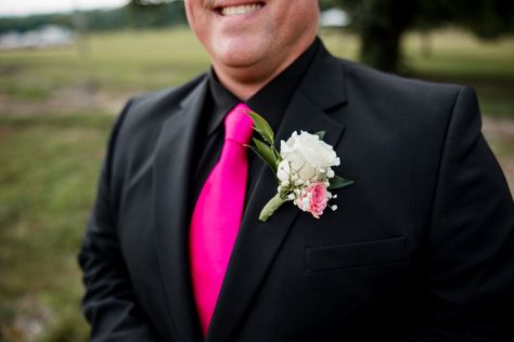 Grooms, listen up. You can add a pop of color to your wedding day attire. This groom rocked an all-black suit with a hot pink tie and boutonniere to match the brides bouquet. | John Myers Photography & Videography All Black Suit With Pink Tie, Black Suit With Pink Tie, Black Suit Pink Tie, Pink Groomsmen Attire, Full Black Suit, All Black Tux, Pink Groomsmen, Homecoming 2024, John Myers