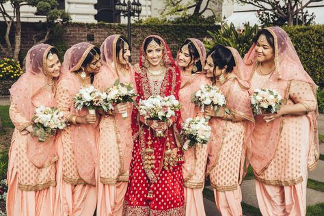 Indian bride in her red lengha with her bridesmaids in peach lengha. South Asian Wedding Bridal Party. Punjabi Bridesmaids Outfits, Shadi Photography, Punjabi Bridesmaids, Mehndi Suits, Indian Bridesmaids Outfits, Bridesmaids Pictures, Nikkah Photography, Indian Wedding Bridesmaids, Bridesmaid Suits