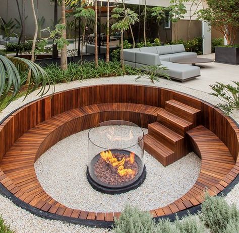 a contemporary sunken fire pit with a built in stained bench and steps plus a fire pit in the center clad with glass Sunken Patio, Sunken Fire Pits, Outdoor Fire Pit Designs, Fire Pit Landscaping, Fire Pit Designs, Backyard Fire, Backyard Garden Design, Fire Pit Backyard, Small Backyard Pools