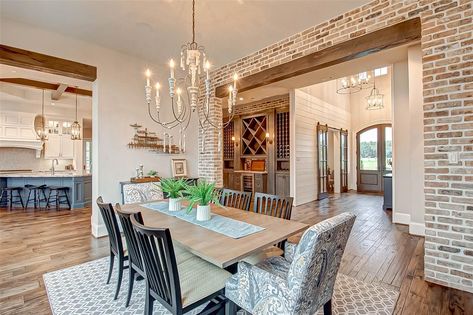 2047 Bennet Lane, Conroe, TX 77384: Photo The formal dining room is bejeweled with a custom wrought iron and wood fixture and trimmed with reclaimed Chicago brick accent walls and finished with wood beams.. The walnut wood floors are constructed of varying widths and flow throughout the main level. Dining Room Brick Accent Wall, Brick And Wood Living Room, Brick Wall With Wood Beam, Barndo Dining Room, Dining Room Brick Wall, Brick Wall Dining Room, Brick Dining Room, Den Remodel, Great Room Layout