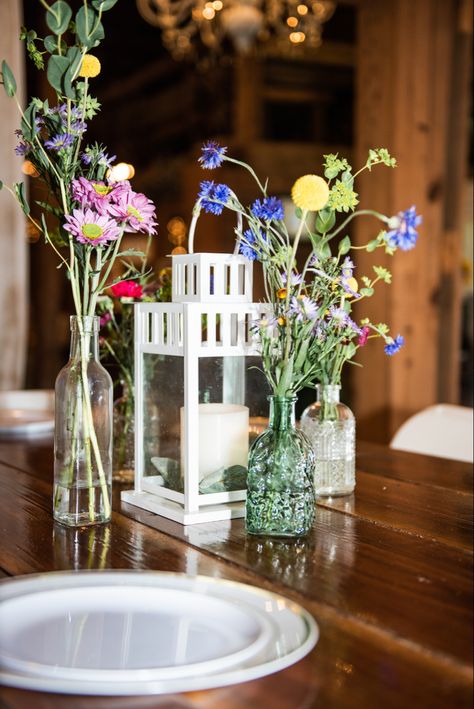 Colorful Wedding Center Piece we went for a wildflower vibe and many mini jars. The most of them were found at dollar tree! Flowers from trader joes! Trader Joe’s Wedding Flowers, Wildflower Mason Jar Centerpieces, Wildflower Small Centerpiece, Blue Wild Flower Centerpieces, Wildflowers In Mason Jars, Wild Flowers In Mason Jars, Jewel Tone Wedding Theme, Jewel Tone Wedding, Mini Jars