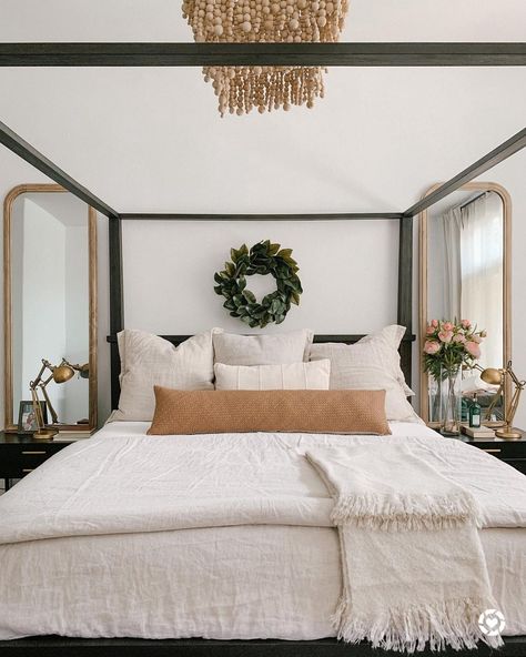 A black canopy bed in beige, ivory and tan bedding is lit by a beige beaded chandelier. Brushed gold lamps for bedroom stand in front of light wood frame mirrors on black and brass side tables flanking the bed. Black Canopy Bed, Canopy Bed Diy, Transitional Decor Bedroom, Canopy Bedroom, Poster Bed, Modern Bedroom Furniture, Up House, Contemporary Bed, Canopy Bed