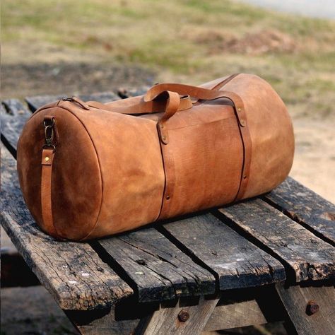 "DIMENSIONS: 10\"H x 20\"W x 10\"D Our Leather Duffel Bag is made from Top Grain Cowhide leather. We kept this leather weekender mens leather bag minimalist, spacious and classy. YKK # 5 Zipper will let you zip and unzip this travel duffle bag with all the ease in the world. Don't worry about arranging your essentials for your weekend getaway anymore. This handmade vintage leather travel bag has a front pocket, single inside pocket and two D shaped pockets on both ends; meaning nothing you want Vintage Leather Travel Bag, Leather Overnight Bag, Leather Duffel Bag, Leather Weekender Bag, Leather Duffel, Leather Weekender, Minimalist Bag, Sac Week End, Leather Duffle Bag