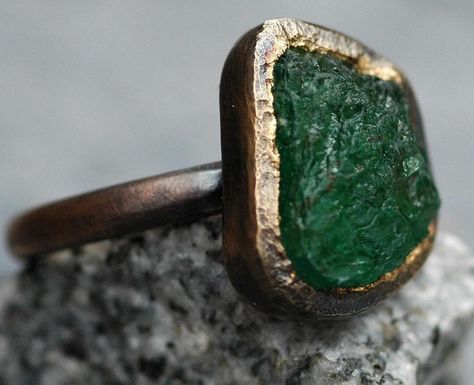 Here’s one of my gigantic raw emeralds set into my hand-fabricated oxidized 18k rose gold engagement and wedding ring set. Each of these ring sets is designed around a large, untreated raw emerald that I source specifically for the project. I have been setting uncut emeralds, diamonds, sapphires and rubies (as well as most of the semi-precious category of gemstones) into my work since 2008. Get in touch if your dream ring is centred around the raw and the rough. #rawemerald #roughemerald ... Uncut Emerald Engagement Ring, Rough Emerald Ring, Gold Engagement And Wedding Ring, Adjustable Gold Rings With Raw Stone, Unique Green Jewelry With Raw Stone, Engagement And Wedding Ring Set, Raw Stone Engagement Rings, Engagement And Wedding Ring, Raw Emerald