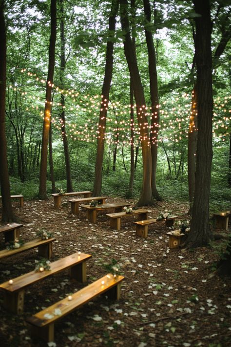 A serene outdoor setting in a forest with simple wooden benches arranged in rows, surrounded by tall trees. Delicate string lights hang above, creating a cozy atmosphere. The ground is covered with scattered flower petals. Ceremony In The Woods, Wedding In Pine Trees, Woods Ceremony Wedding, Forest Wedding Simple, Enchanted Forest Wedding Diy, Tree Decorations Outdoor Wedding, Simple Forest Wedding, Field Wedding Reception, Fairy Forest Wedding