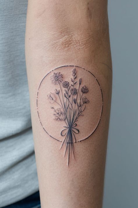 Enclose a small bouquet of wildflowers in a simple circle on the forearm for a balanced and artistic look. The circular shape adds structure, while the wildflowers inside maintain their natural beauty. Dried Flower Bouquet Tattoo, Dainty Wildflower Tattoo, Above Elbow Tattoos For Women, Wildflower Tattoo Ideas, Above Elbow Tattoo, Red Insects, Wildflower Crown, Dahlia Tattoo, Bouquet Of Wildflowers