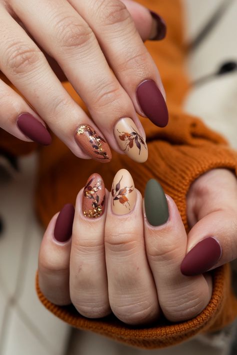 Embrace the warmth of autumn with these delightful oval fall nail ideas. Picture your nails adorned in rich burgundy and golden accents, perfectly capturing the essence of the season. The oval shape adds elegance, showcasing intricate leaf designs that evoke the beauty of falling leaves. This nail style is not only trendy but also a fabulous way to celebrate the cozy vibes of fall. Tap into your creativity and let your nails reflect the charm of the season! Oval Nails Ideas Fall, Fall Nail Designs Floral, Thanksgiving Nails Acrylic Oval, Maniology Fall Nails, Fall Leaves Manicure, Fall Almond Nails Ideas Green, Oval Nail Ideas Fall, Autumn Nails With Leaves, Oval Fall Nails Acrylic