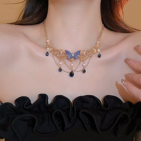 A stunning gold-plated necklace featuring a large, vibrant blue butterfly centerpiece. Five delicate pearls adorn the butterfly, while a cascading tassel of teardrop blue rhinestones adds a touch of glamorous sparkle.#vintagenecklace #vintagestyle #vintagejewelry #vintage #rosycozy #butterflyjewelry #butterflynecklace #fashion #jewelry #retro Baby Blue Butterfly, Butterfly Centerpiece, Blue Butterfly Necklace, Butterfly Centerpieces, Butterfly Jewelry, Butterfly Necklace, Vibrant Blue, The Butterfly, Blue Rhinestones