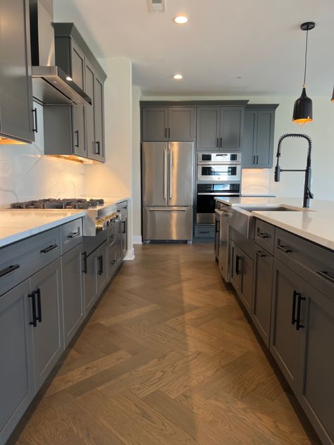 Grey kitchen cabinets with natural wood herringbone floors, black kitchen hardware Dark Grey Cabinets With Black Hardware, Grey Black Kitchen Cabinets, Black Hardware On Gray Cabinets, Grey Kitchen Cabinets With Black Handles, Blue Kitchen Cabinets With Black Handles, Gray Kitchen Cabinets Black Hardware, Gray Cabinets Black Hardware, Brown Cabinets Grey Floor, Grey Tile Kitchen Floor Wood Cabinets