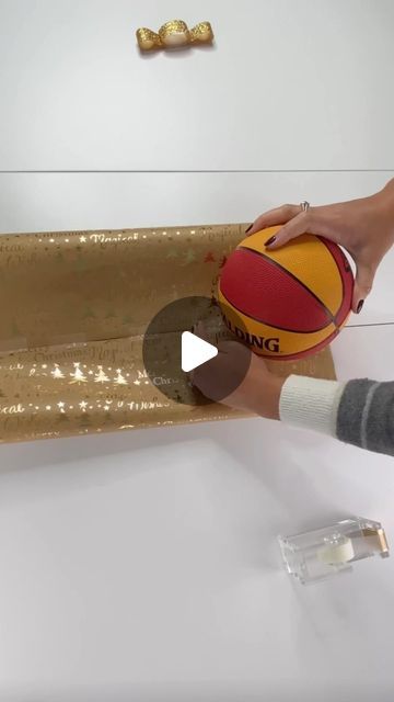 Football Gift Wrapping Ideas, How To Wrap A Ball Present, Wrap A Ball With Paper, Ball Wrapping Gift, How To Wrap A Baseball Bat As A Gift, Wrapping A Ball Gift, How To Gift Wrap A Ball, Gift Wrap Round Objects, How To Wrap A Basketball