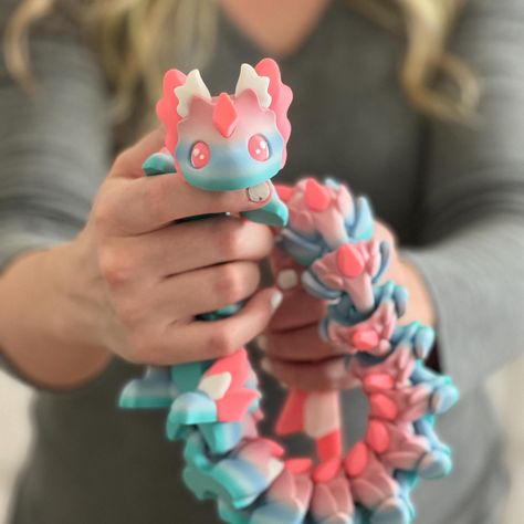 This amazing Custom 3D Printed Articulated Dragon fidget spinner comes in three sizes and several beautiful colors! Our enchanting and functional decor piece adds a touch of fantasy to any space and makes a wonderful and unique present. Made with eco-friendly materials (biodegradable filaments), this beautiful dragon makes an ideal gift for all ages, from dragon enthusiasts to bookworms looking to add a little fantasy to their surroundings. 📸 Model #1 Details:        24" Adult, 3 Color Print       Slow Rainbow Gradient (because this model is so large, several colors showed in the print)       Glow in the Dark Pink       White 🐉 Size：       17" Adult       21" Adult       24" Adult All of our cryptids, critters, and magical creatures are 3D printed in our home with love and attention to d Fidget Toys Aesthetic, 3d Printing Toys, Figet Toys, Cool Fidget Toys, Acrylic Art Projects, 3d Printing Art, 3d Printing Diy, 3d Printed Objects, Rainbow Gradient