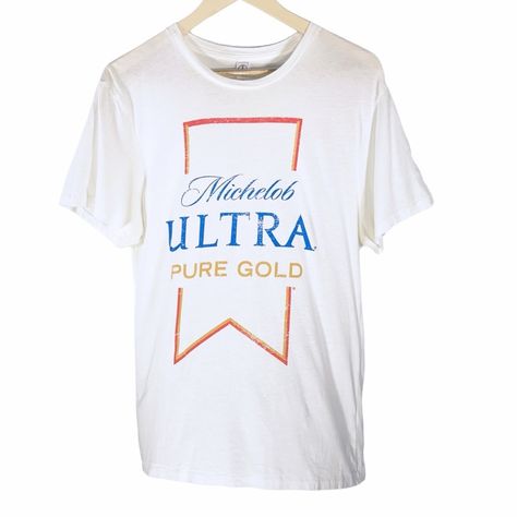 This Michelob Ultra Pure Gold T-Shirt Is The Epitome Of Comfort And Style, Tailored For Both Men And Women. Crafted From Organic Cotton, It Features A Striking Graphic Print With The Official Michelob Ultra Logo. The Crew Neck And Short Sleeves Make It An Ideal Choice For Any Casual Occasion, From Beer Festivals To Relaxed Home Lounging. It's Also Machine Washable For Easy Care. #Michelobultra #Puregold #Tshirt #Unisexadults #Graphicprint #Shortsleeve #Officialmerchandise #Logo #Crewneck #Organi Michelob Ultra Logo, Relaxed Home, Tech Women, Michelob Ultra, Women Shirt Top, Camo Shirts, Concert Tees, Women Shirt, Pure Gold