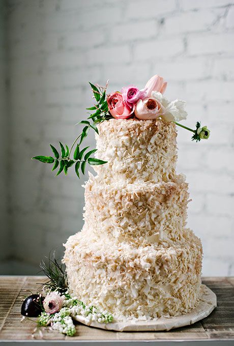 A coconut-covered three-tiered wedding cake with a fresh flower topper by @sugarbeesweets | Brides.com Coconut Wedding Cake, Coconut Wedding, Cream Wedding Cakes, Spring Wedding Cake, Romantic Wedding Cake, Naked Cakes, Tiered Cake, Fall Wedding Cakes, Wedding Dessert