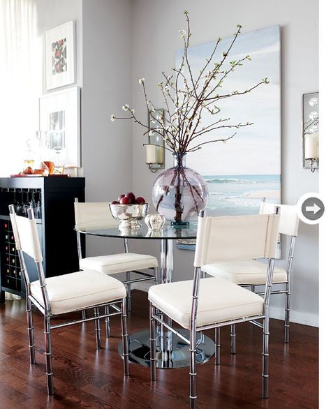 Dining room  Lindsay took advantage of a small nook in the main living space and created an elegant dining area by incorporating glass and metal furniture with clean lines. The round dining table ensures ease of flow, while the light, airy quality of the chairs makes them less obtrusive in the open-concept layout. Round Glass Dining Room Table, Glass Table Living Room, Glass Kitchen Tables, Glass Dining Room Table, Condo Living, Kitchen Table Settings, Home Goods Decor, Glass Dining Table, Livingroom Layout