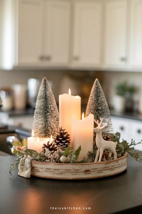 Festive centerpiece with lit candles, miniature snowy trees, and a reindeer figurine. Open Shelf Christmas Decor Kitchen, Round Table Xmas Decor, Christmas Farmhouse Centerpiece Ideas, Christmas Kitchen Island Decor Ideas Modern, Christmas Decor Ideas Tray, Rustic Winter Table Decor, Christmas Decorative Tray, Holiday Island Decor, Christmas Home Decor Kitchen