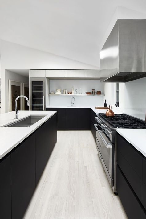 Darker tones bring contemporary drama and sophistication. These gorgeous kitchens, featuring dark or black kitchen islands, provide contrast to the surrounding countertops and cabinetry, or match the already deep tones of the space. Take a look below to find inspiration for this trend.  #blackkitchen #blackcabinetry #blackkitchenisland #kitchenisland #modernkitchen Kitchens With Dark Islands, Black Kitchen Islands, Slc Interiors, Glass Upper Cabinets, Kitchen Design Countertops, Hamptons Kitchen, Contemporary Style Kitchen, Art Deco Kitchen, Marble Countertops Kitchen