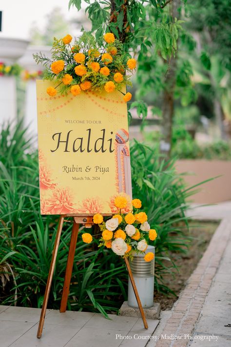 Haldi entrance standee, minimalist design, floral touch, wedding decor, wedding planning, wedding inspiration, Indian wedding, elegant entrance, simple decor, wedding festivities, sunkissed affair, subtle decor, yellow flowers, Haldi decor, Wedding invitations, Wedding entrance decor Haldi Entrance Decoration Ideas, Haldi Standee Design, Poolside Haldi Decor, Simple Decor Wedding, Haldi Standee, Wedding Standee Design, Beach Sangeet, Haldi Entrance, Haldi Ceremony Decorations